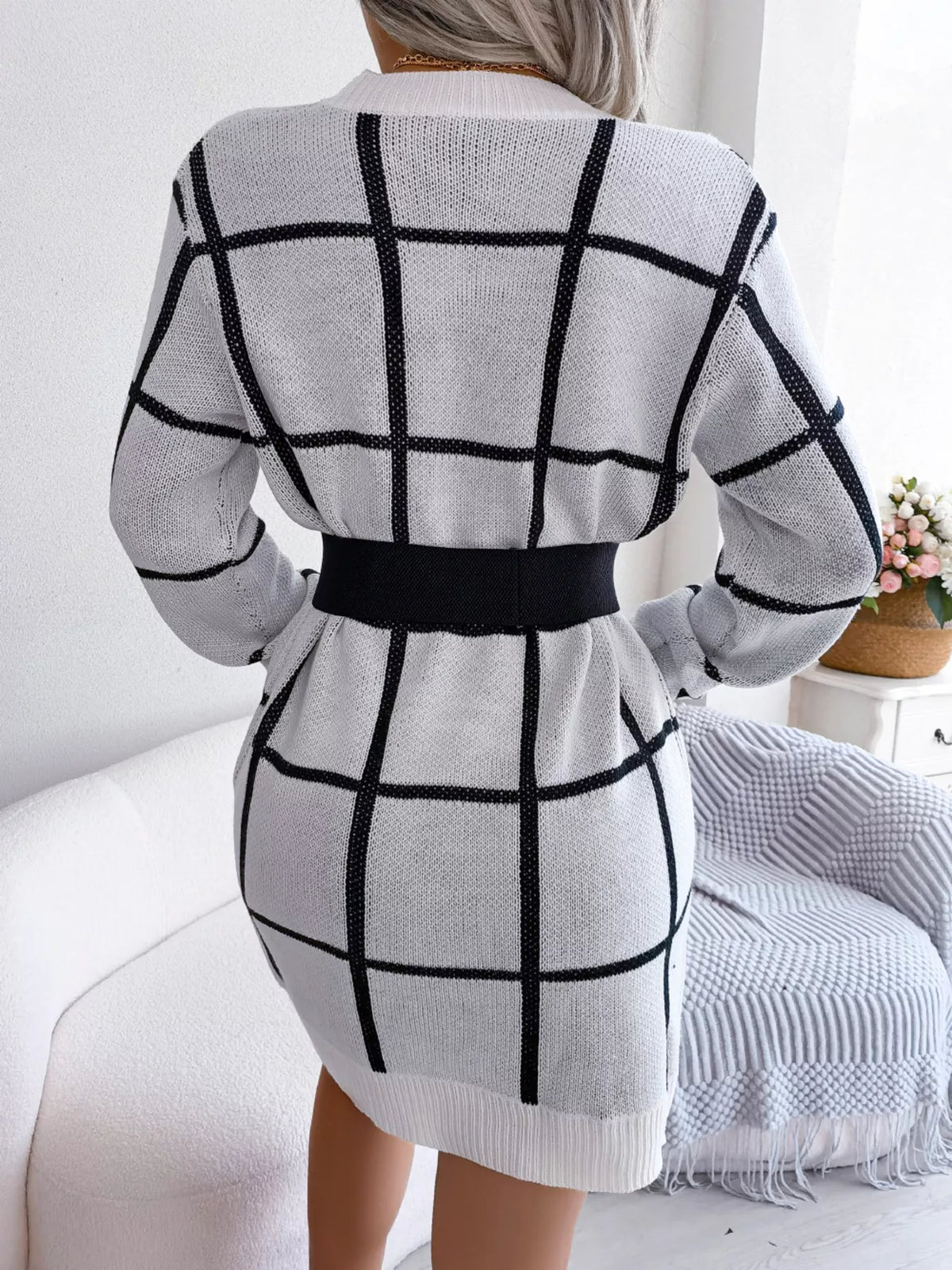 Back view of the White knit sweater dress with a black windowpane grid pattern, styled with a black belt (belt not included)