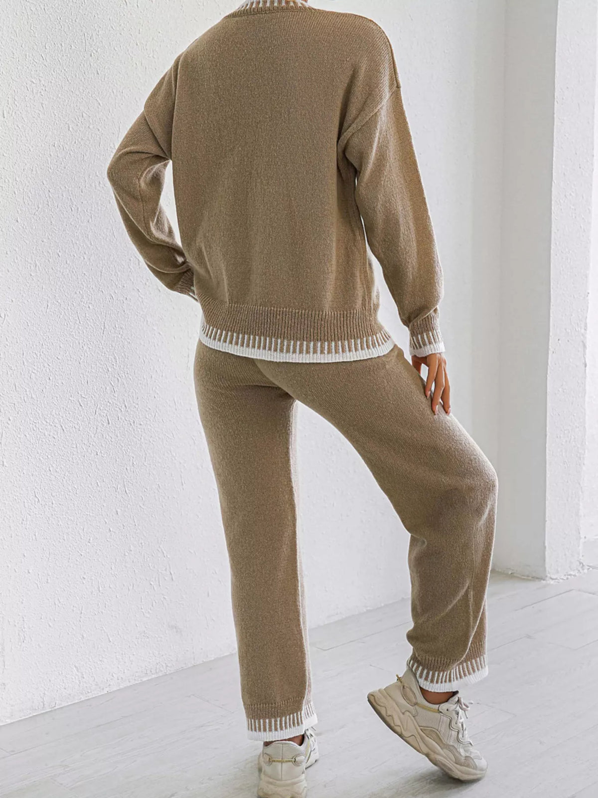 Back view of the Taupe knit sweater and pants set with white contrast stitching at the sweater hem, cuffs and pant hems