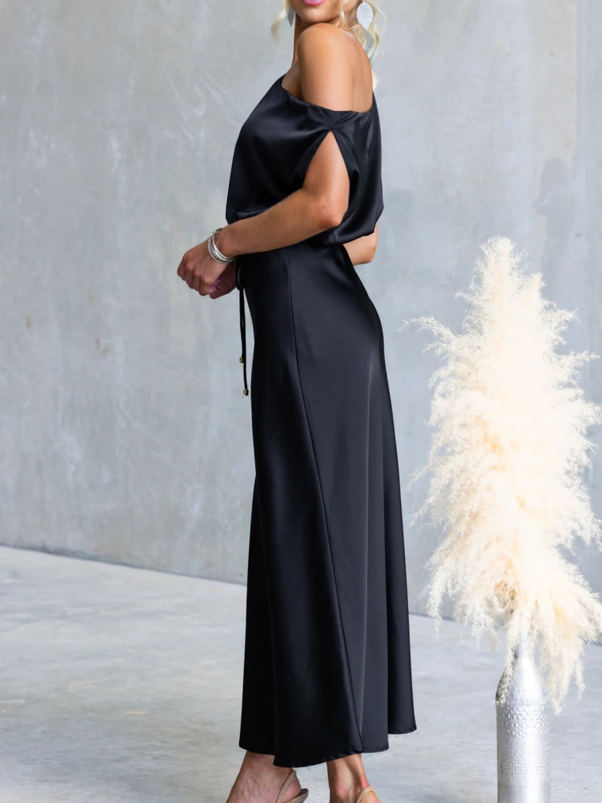 Side view of Black one-shoulder maxi dress with draped sleeve