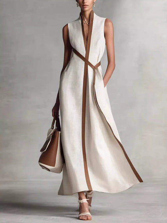 White sleeveless wrap maxi dress with a stand collar, a deep V front edged in brown contrast trim and a tie belt, full-length front view