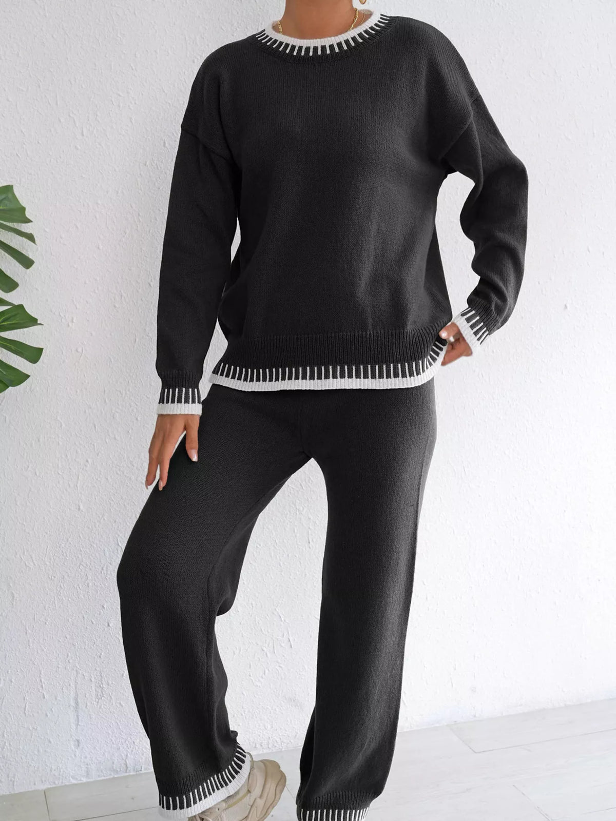 Black knit sweater and pants set, full-length front view with white-stitched hems on the sweater and pants