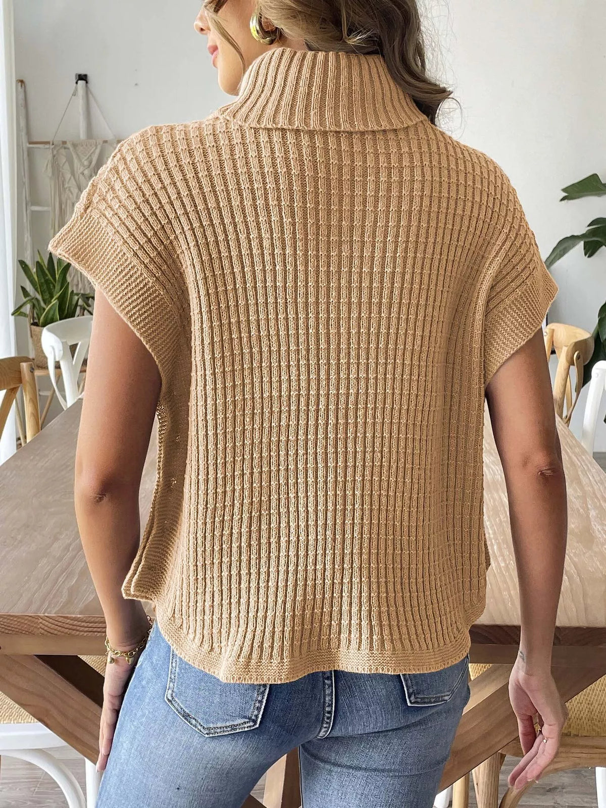 Back view of the camel ribbed turtleneck sweater with short sleeves and a curved hem