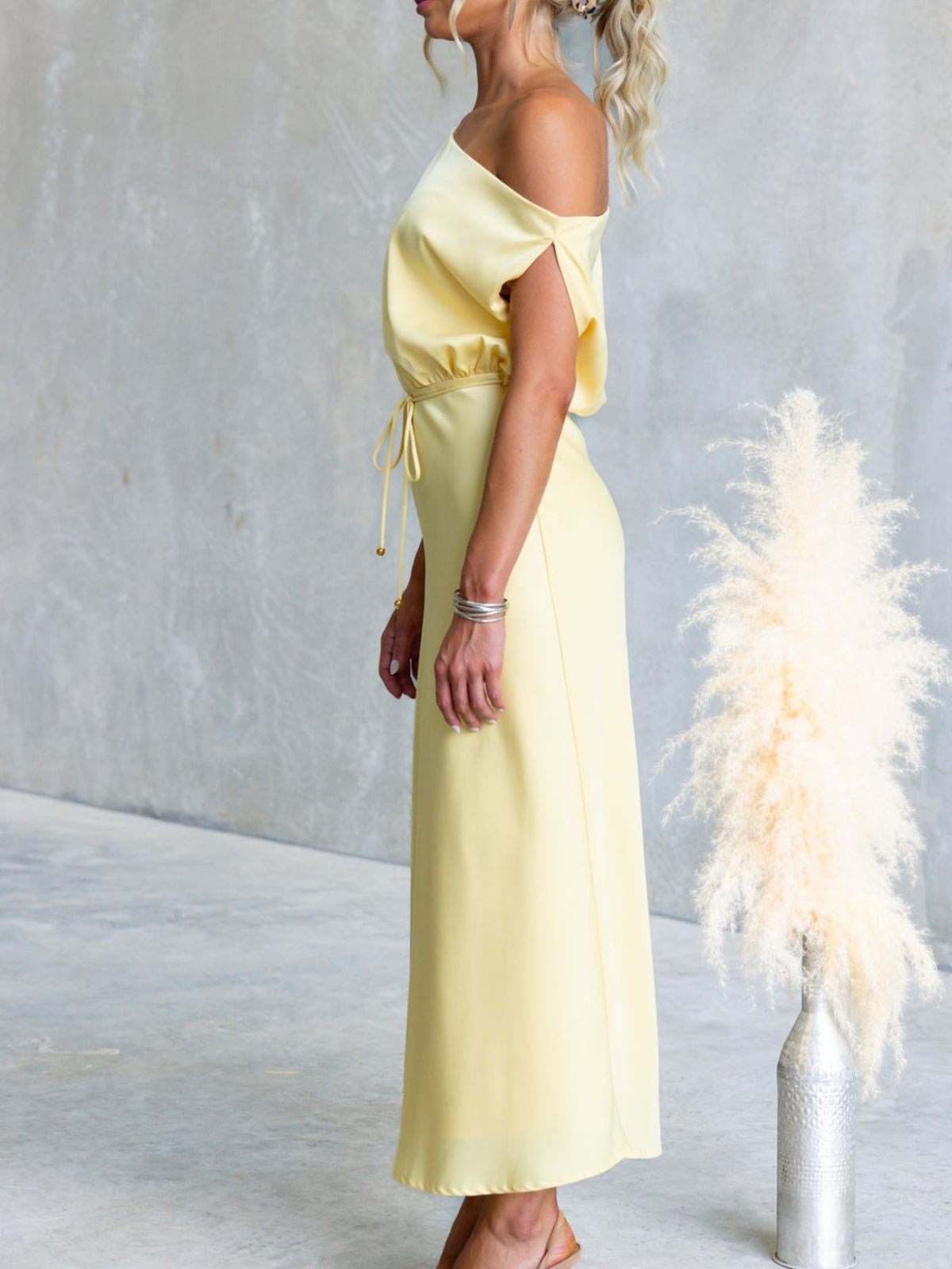 Side view of Yellow one-shoulder maxi dress with draped sleeve