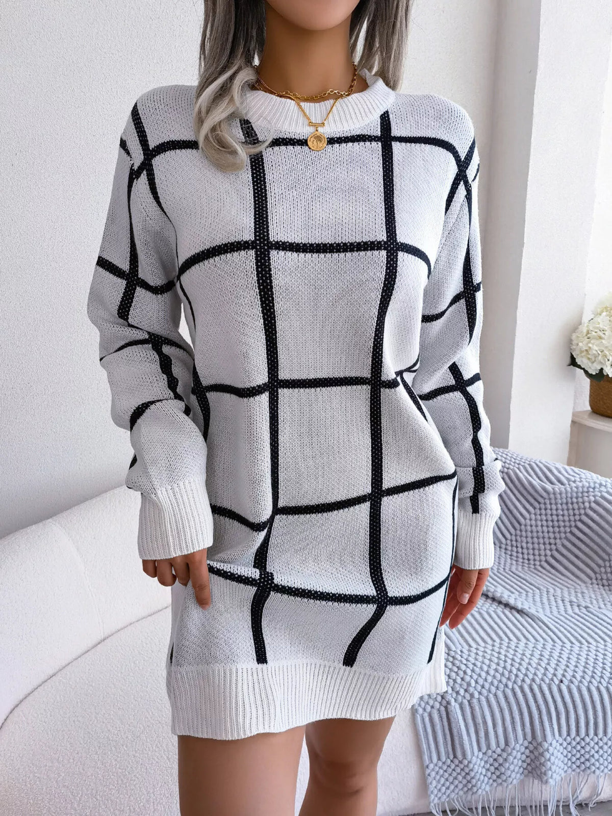 White long sleeve knit mini sweater dress with a black windowpane grid pattern, ribbed neckband, cuffs and hem, front view