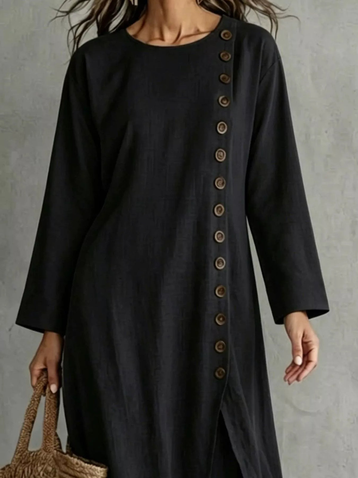 Close view of the round neckline and the row of buttons on the black longline top