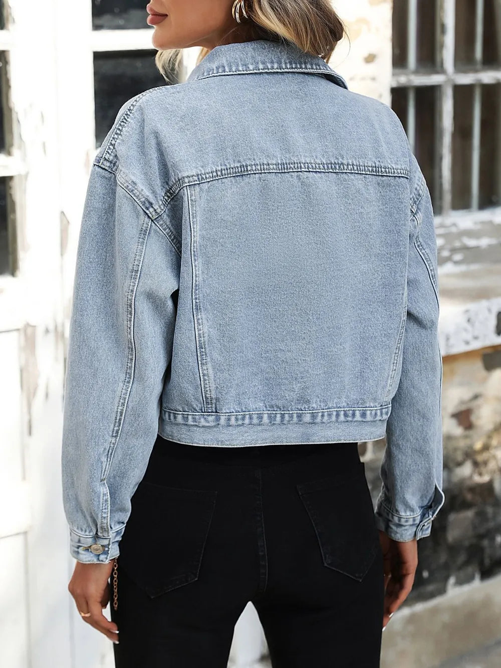 Back of the light wash denim jacket showing the yoke seam and dropped shoulders