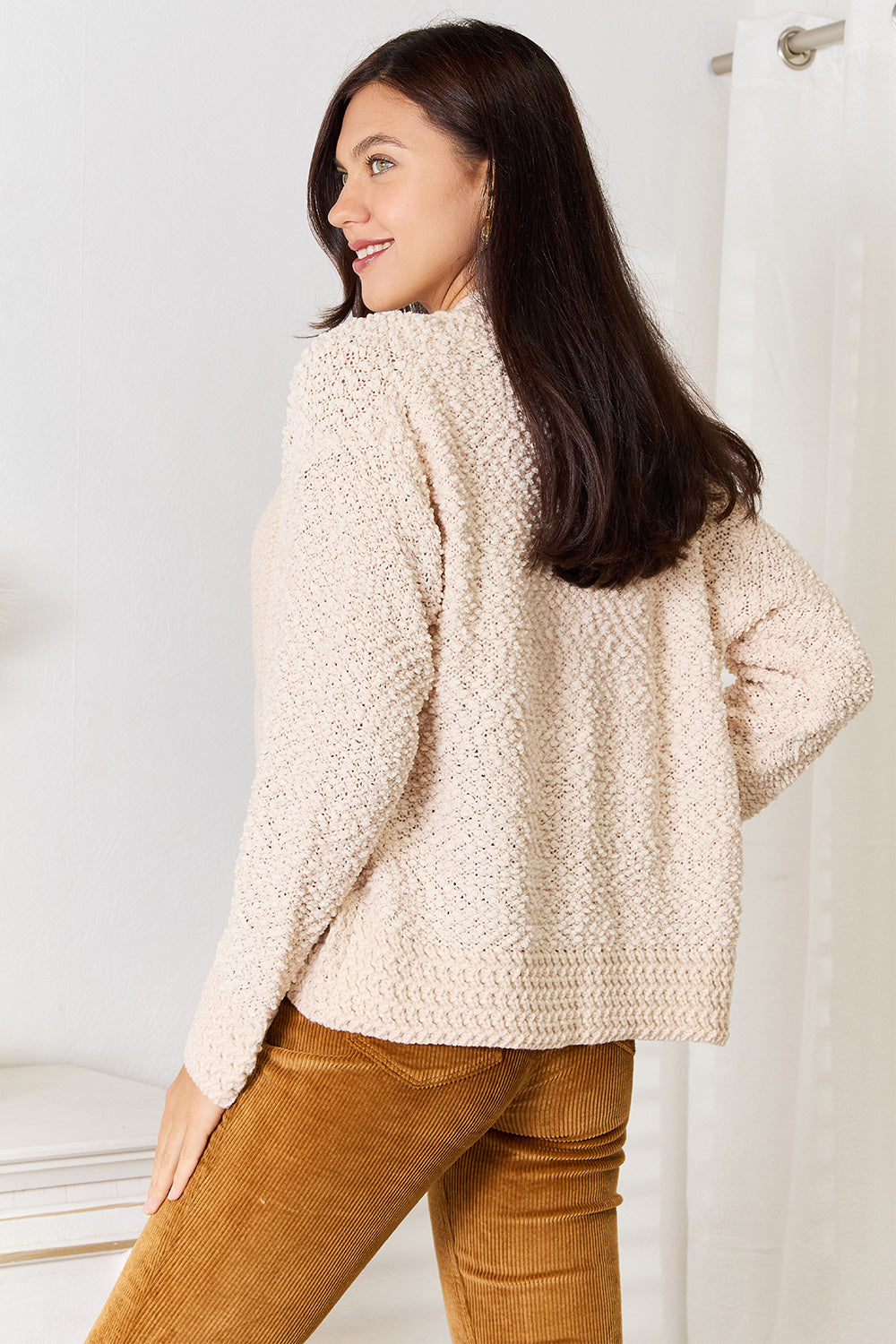 Cream cardigan, back view showing the ribbed hem
