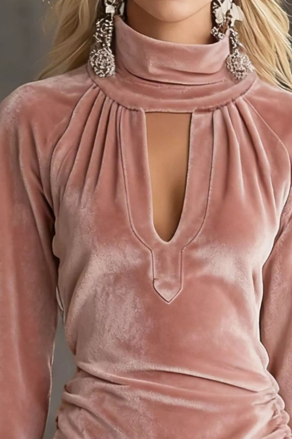 Close-up of the dusty pink velvet mini dress showing the high neck, gathered yoke and front keyhole cutout ending in a small pointed tab