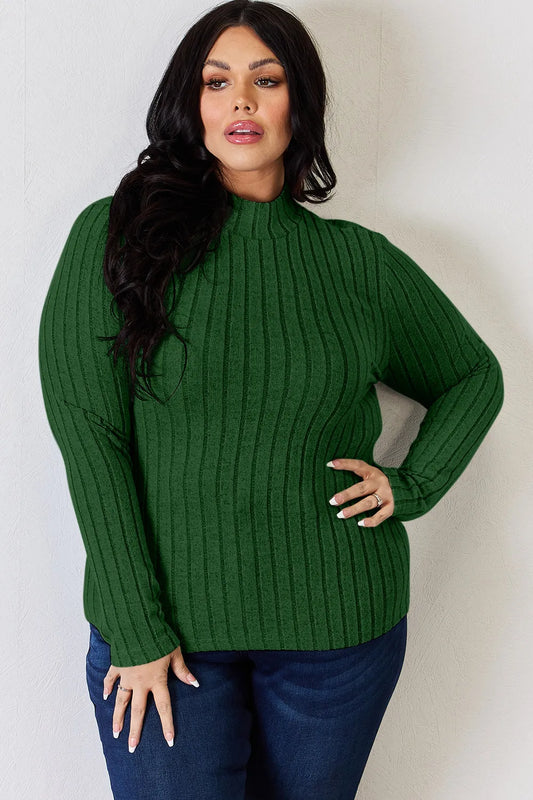 Ribbed mock neck long sleeve tee in Green, a deep forest green, worn with dark jeans, front view