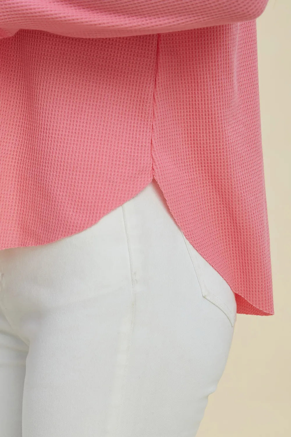Detail of the pink hoodie curved high-low hem