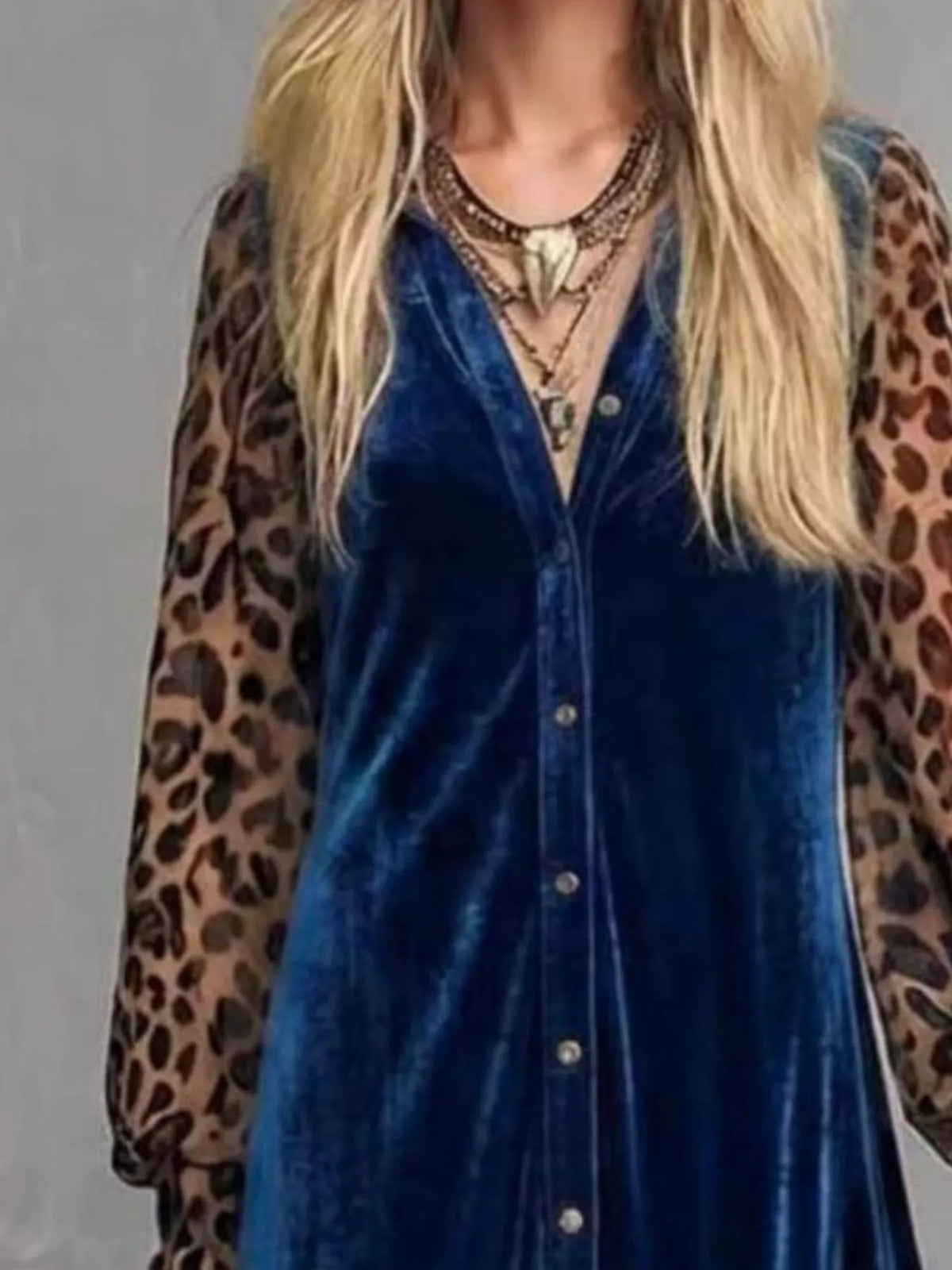 Close-up of the buttoned bodice and leopard print sleeves of a blue velvet maxi dress
