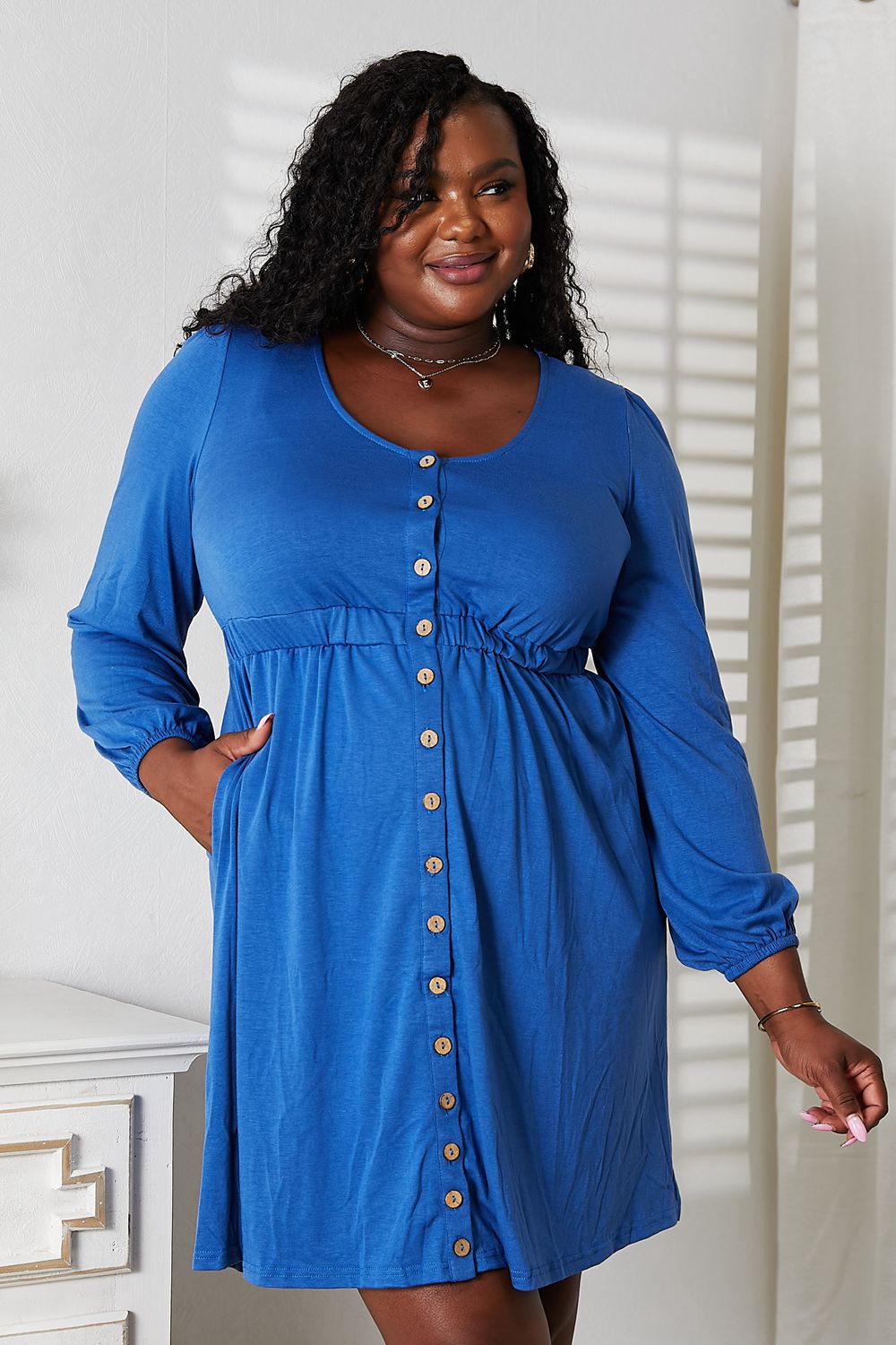 Royal Blue empire waist dress with decorative front buttons and gathered cuffs, front view