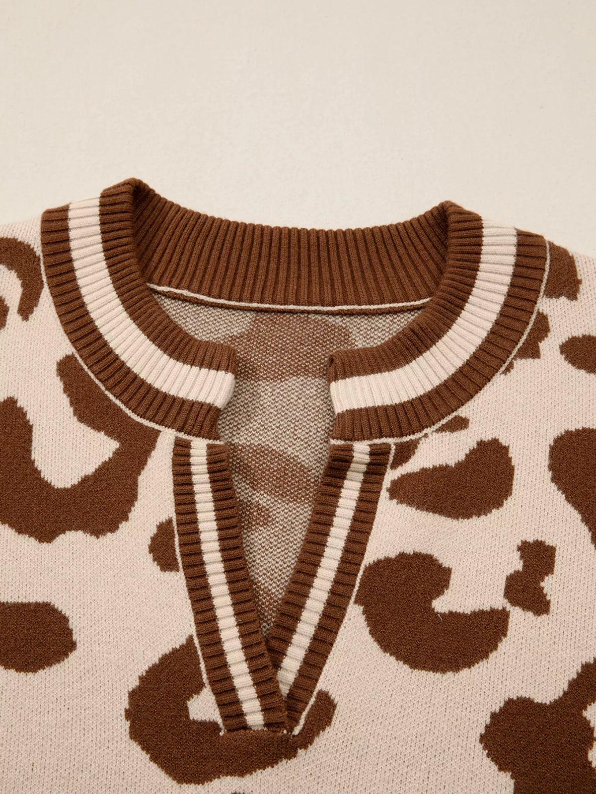 Close-up of the notched V neckline with brown and cream striped rib trim