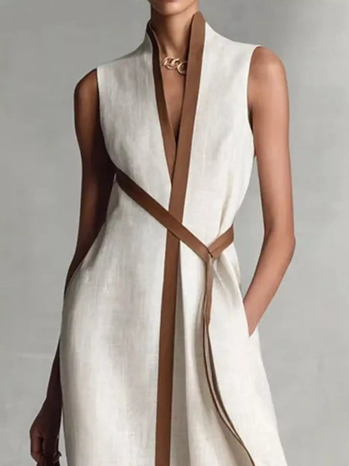 Close view of the White wrap maxi dress showing the stand collar, brown-edged V front, crossed tie belt and side pocket