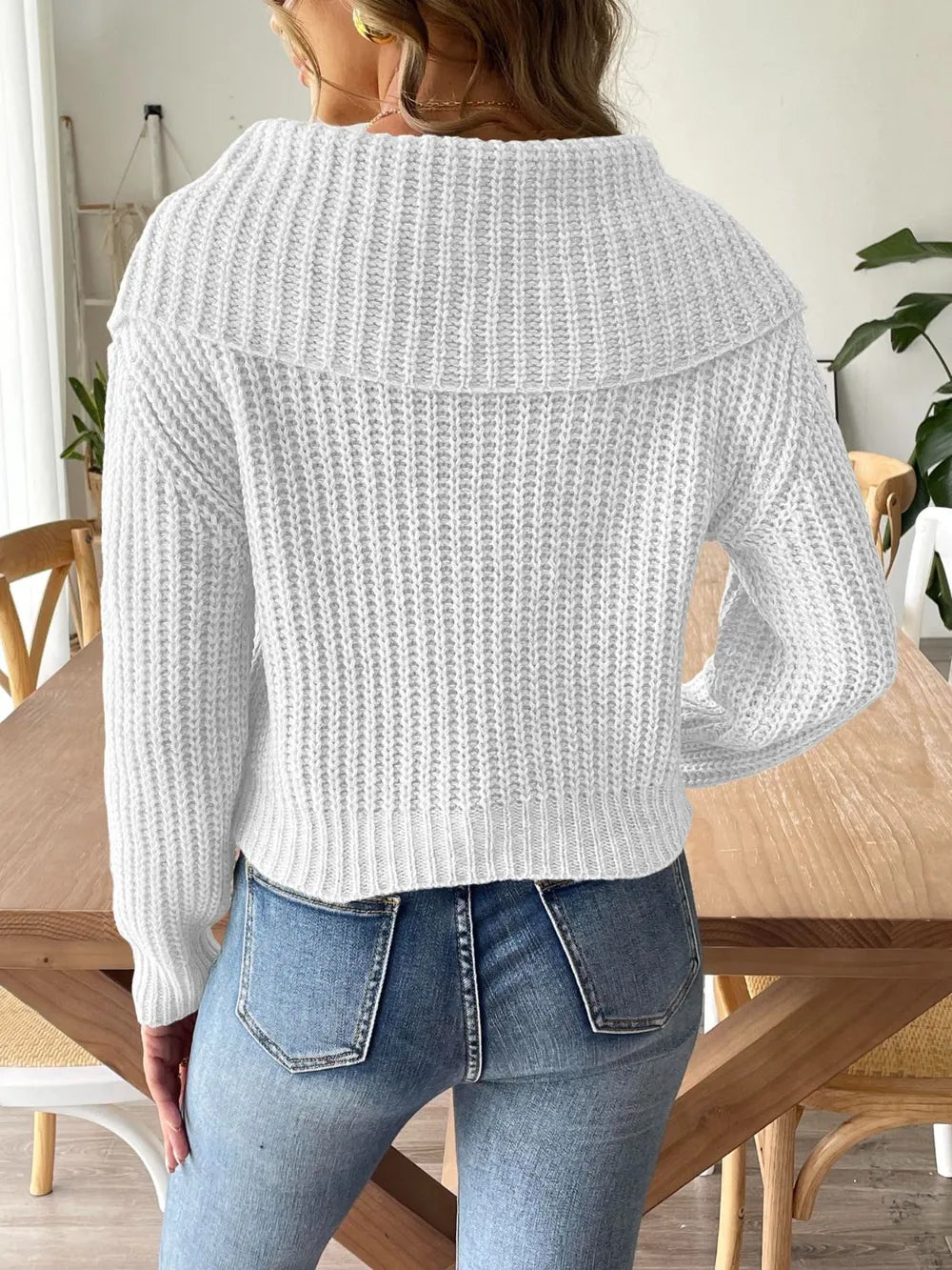 Back view of the white rib-knit sweater with the wide collar across the upper back