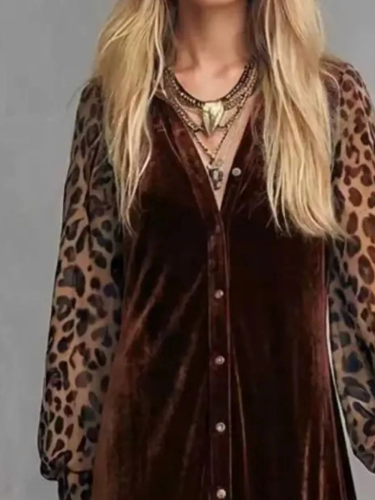 Close-up of the buttoned bodice and leopard print sleeves of a brown velvet maxi dress