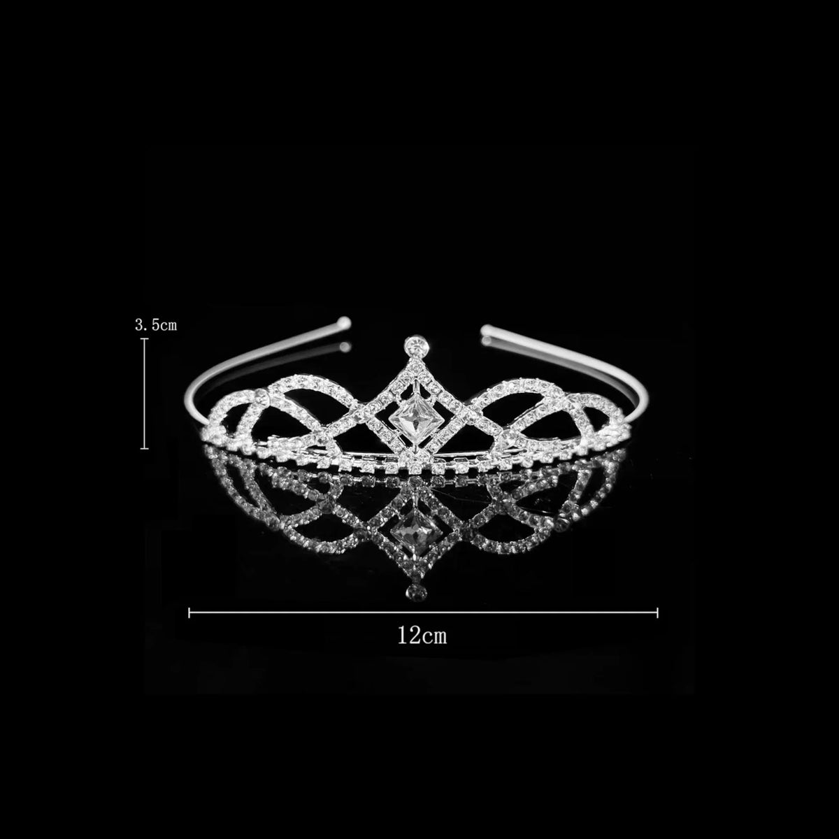 Silver tiara with interlaced looping scrollwork around a diamond-shaped centre crystal — detail