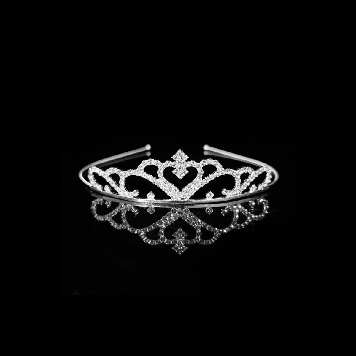 Silver tiara with heart-shaped scrollwork either side of a raised diamond motif