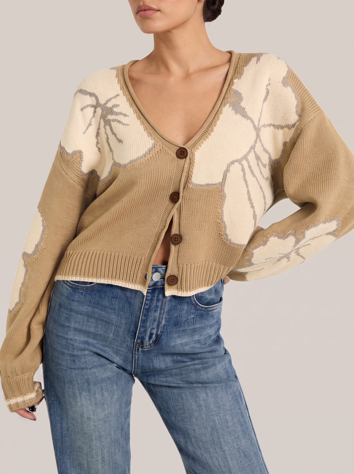 Khaki V-neck button-front cropped knit cardigan with large cream flower motifs and a contrast-tipped hem, front view