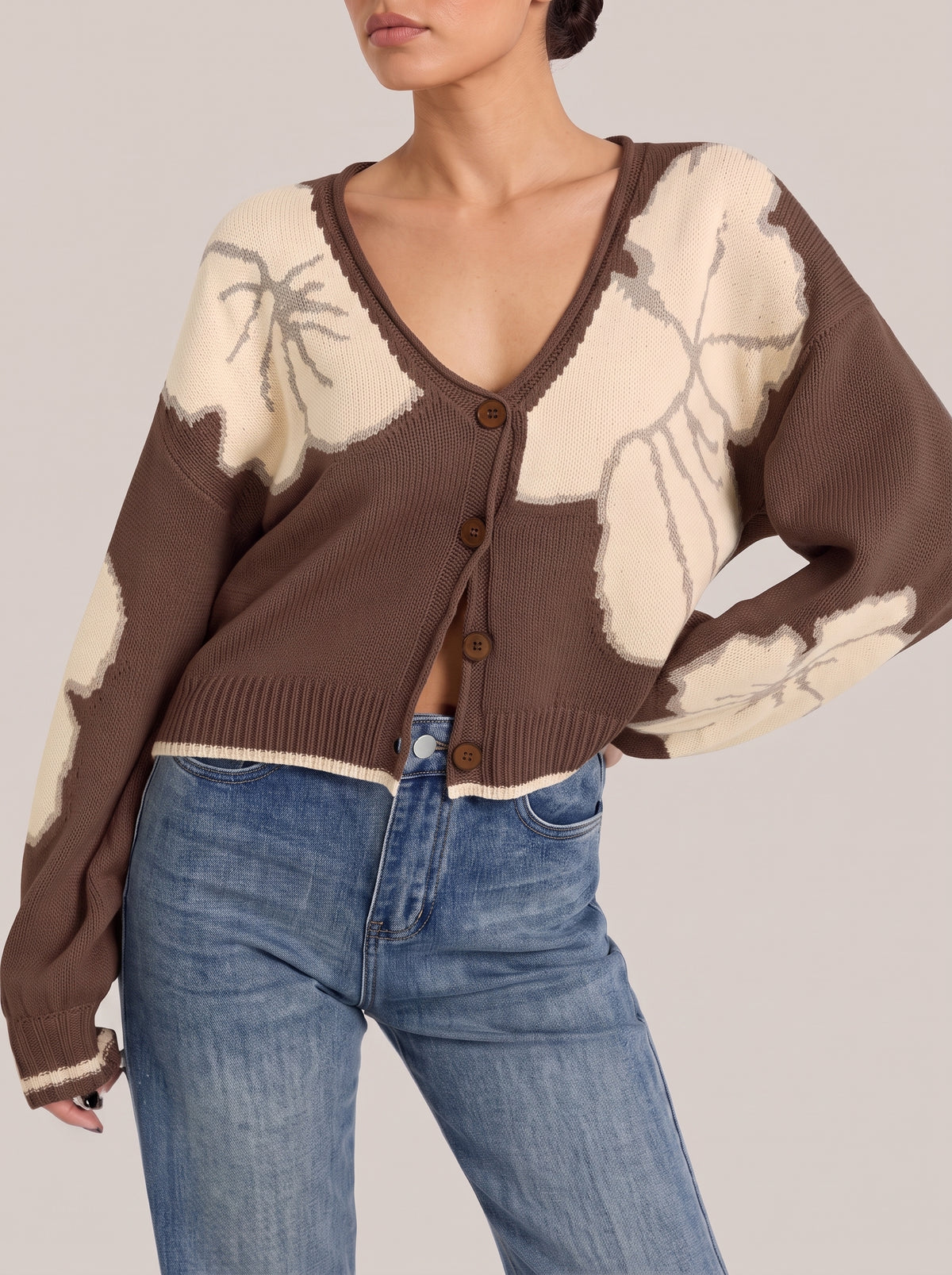 Brown V-neck button-front cropped knit cardigan with large cream flower motifs, front view