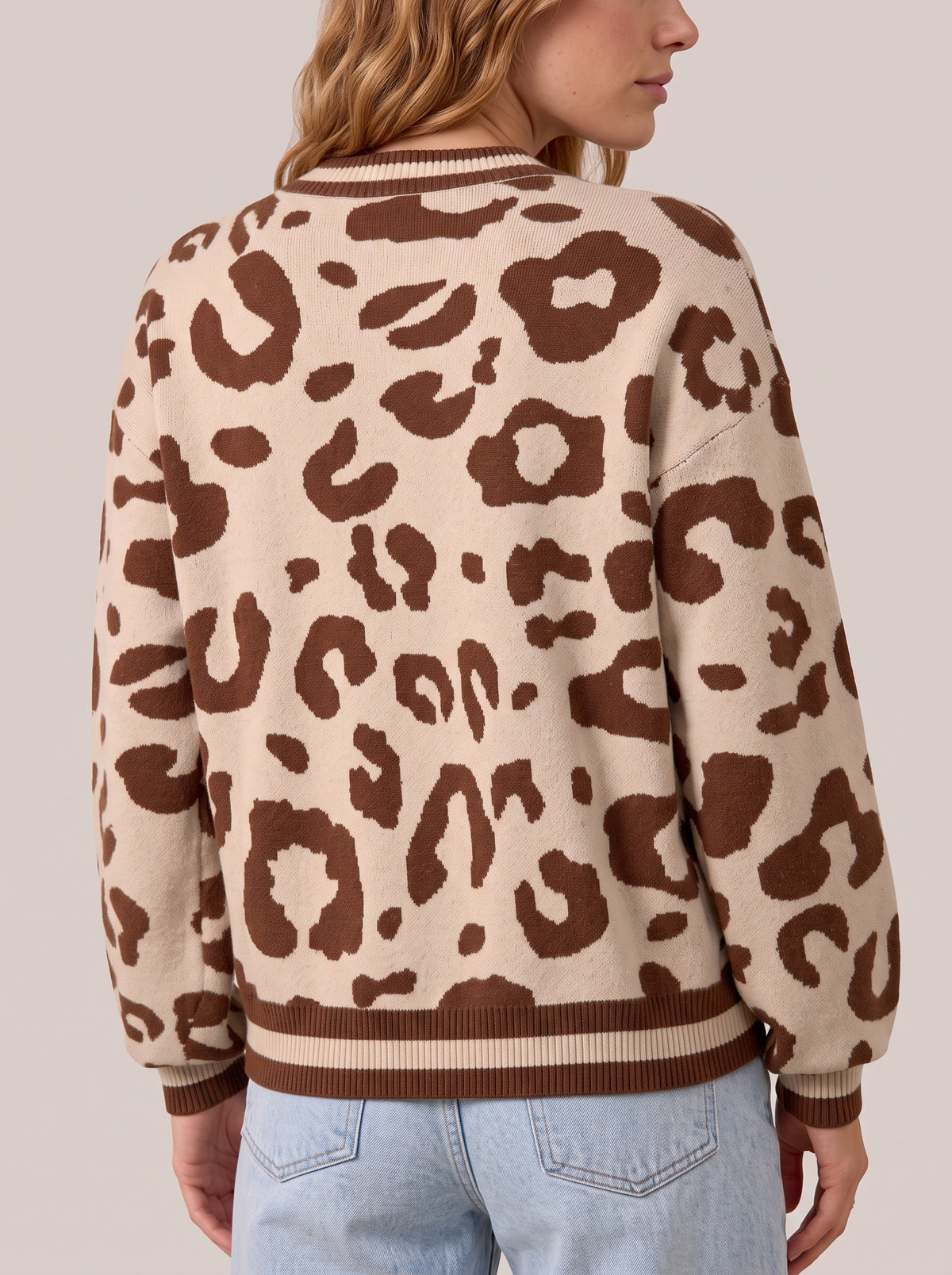 Back view of the leopard print knit sweater with striped rib trim at the neckline, cuffs and hem