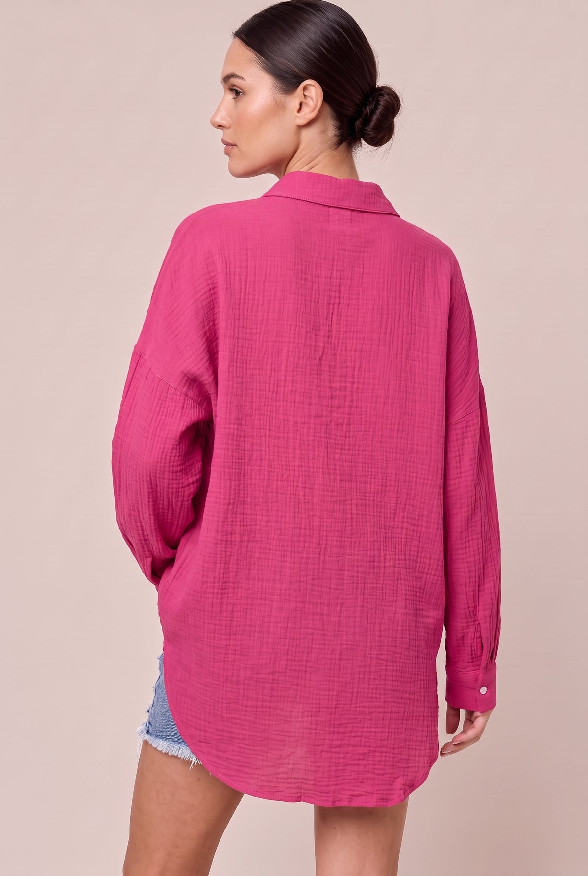 Back view of the Hot Pink textured button-up shirt with a curved high-low hem
