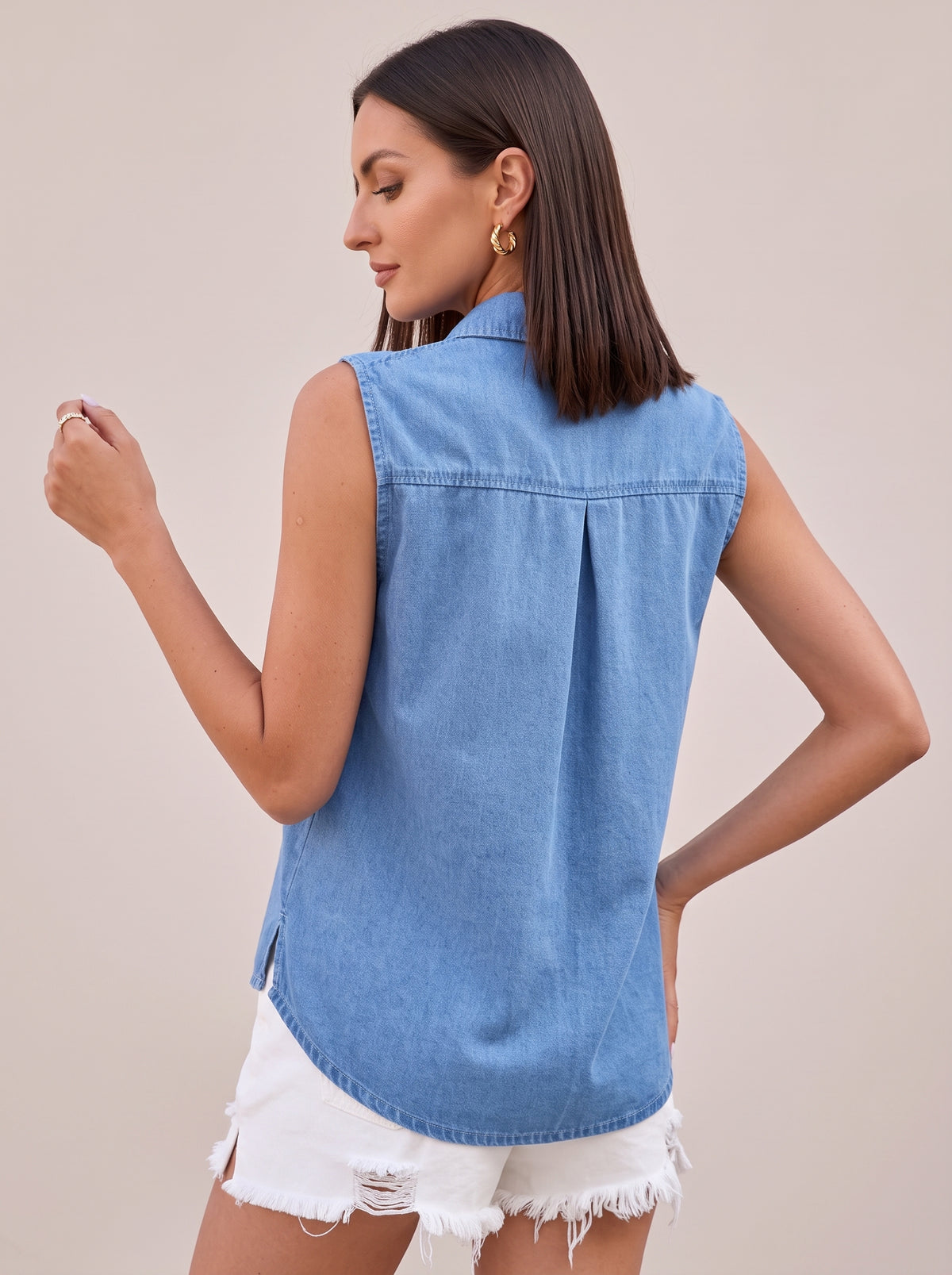 Back of the light blue sleeveless denim top showing the box pleat and curved hem