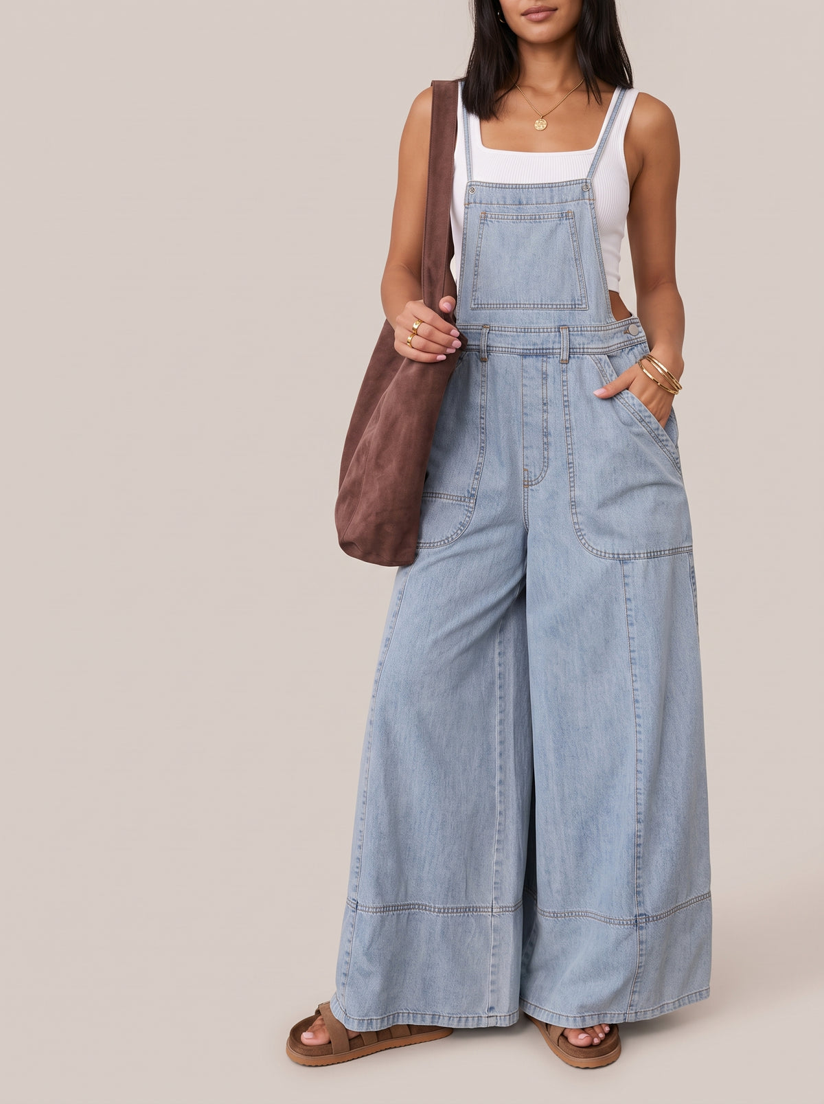 Light blue wide leg denim overalls worn with a white top, front view with front pockets