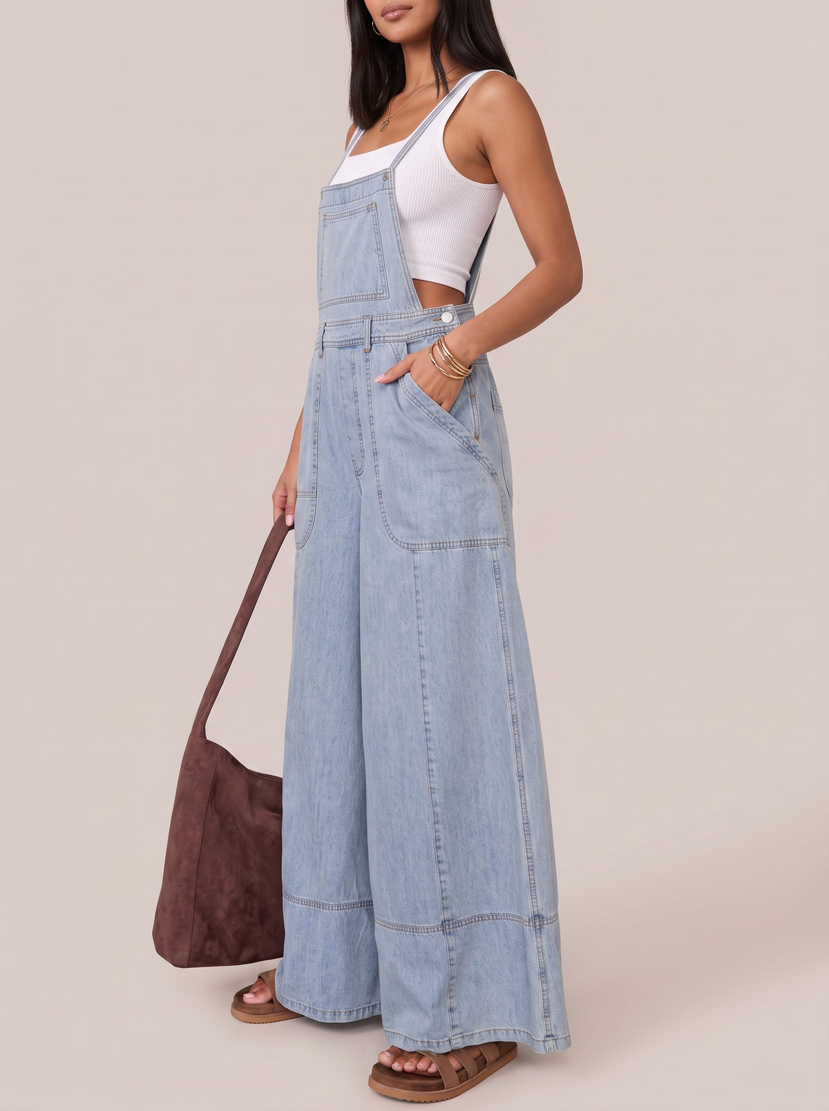 Light blue wide leg denim overalls, side view with hand in the front pocket