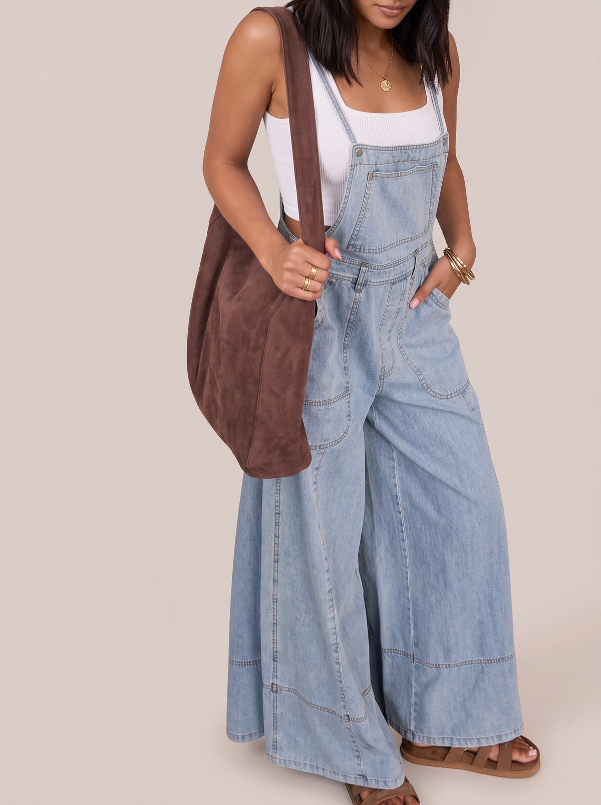 Light blue wide leg denim overalls, front view of the full wide legs and hem topstitching