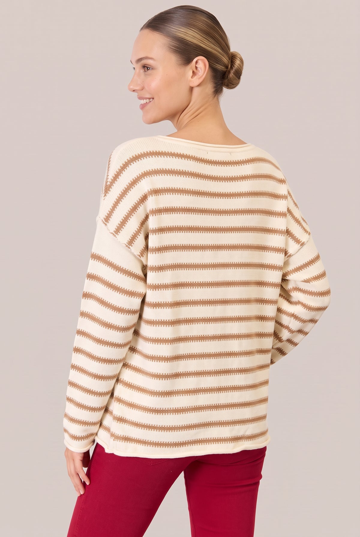 Back view of a cream sweater with camel stripes, dropped shoulders and a rolled hem