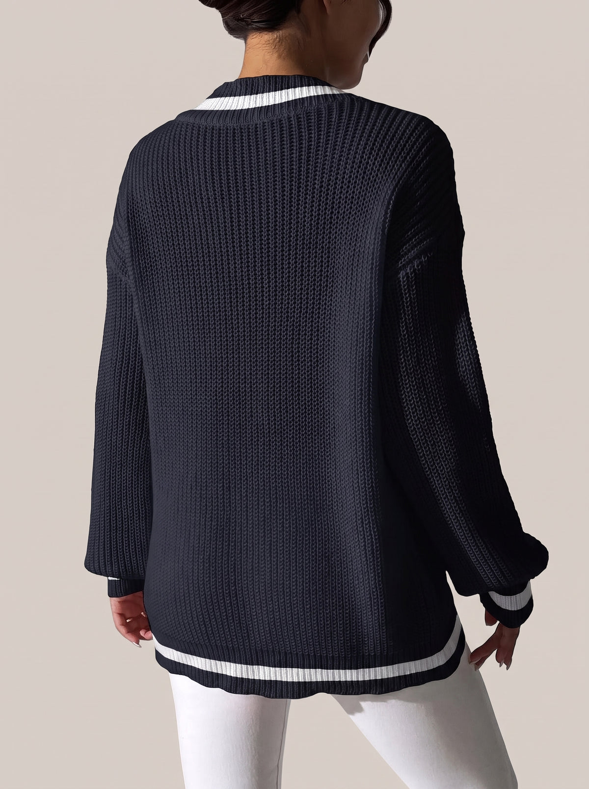 Back view of the dark navy V-neck sweater with white trim at the cuffs and hem