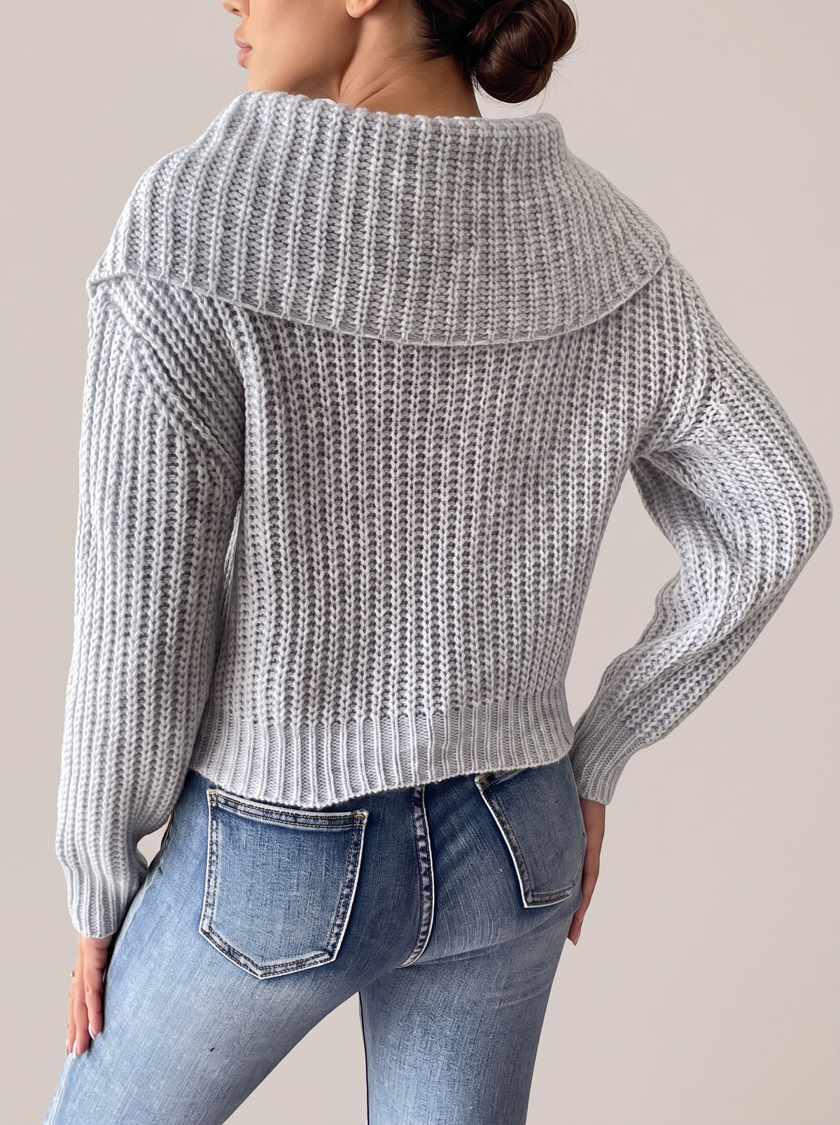 Back view of the gray rib-knit sweater showing the wide collar across the upper back and the ribbed hem
